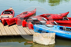 Colorful canoes and kayaks lying on the jetty