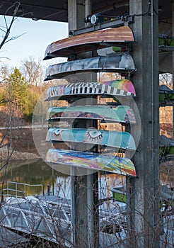 Colorful canoes stored above at a boathouse