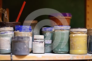Colorful cans of paint on the shelf in the workshop