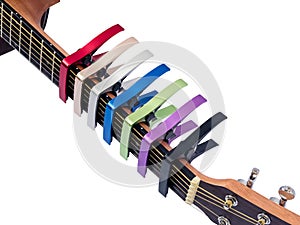 Colorful capo on guitar fingerboard, white background