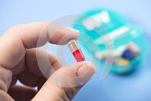 Colorful Capsule In Patient Hand With Daily Pill Dispenser photo