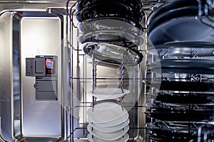 Colorful capsule for washing in a dishwasher dispenser. Top view of a dishwasher filled with dishes