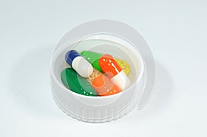 Colorful capsules in a bottle cap