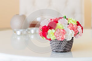 Colorful carnations in brown vase.