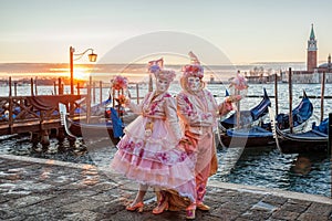 Colorful carnival masks against gondolas at a traditional festival in Venice, Italy