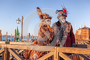 Colorful carnival masks against gondolas at a traditional festival in Venice, Italy