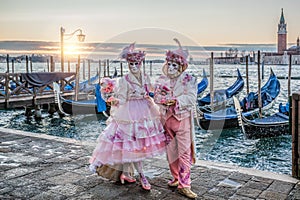 Colorful carnival masks at a traditional festival in Venice against gondolas, Italy