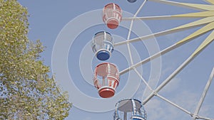 Colorful carousel booths is turns on ferris wheel on blue sky background