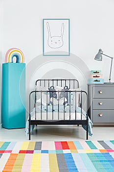 Colorful carpet in kid`s bedroom interior with rabbit poster abo