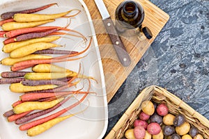 Colorful carrots and potatoes with cutting board