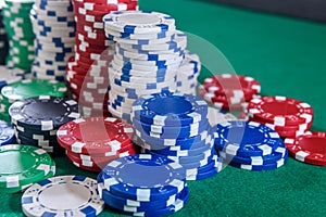 Colorful casino chips on green felt table close up. Gambling concept. Playing poker and other gambling games