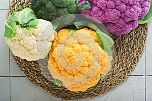 Colorful cauliflower. Various sort of cauliflower on stone tiles gray concrete background. Purple, yellow, white and green color c