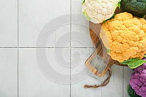 Colorful cauliflower. Various sort of cauliflower on stone tiles gray concrete background. Purple, yellow, white and green color
