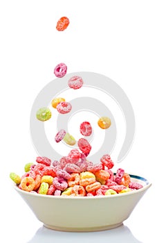 Colorful cereal falling on a white bowl