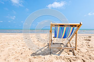 Colorful chair on sandy beach on sunny day looking for the blue