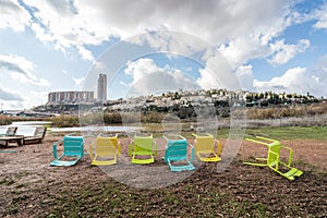 Colorful chairs set in the rain on muddy ground,