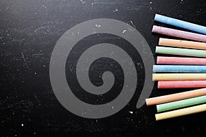 Colorful chalks on blackboard for back to school theme.