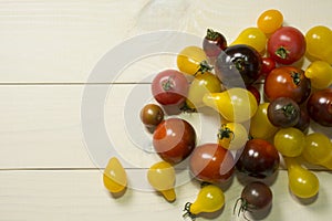 Colorful cherry tomatoes on wooden table background. Organic food