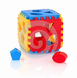 Colorful children`s toy shape sorter isolated on white background with shadow reflection. The cubed shape sorter. photo