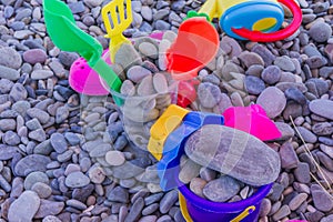 Colorful children toys on pebble beach. Leisure and vacation concept