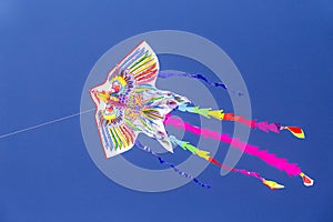 Colorful chinese kite flying in the blue sky with white clouds