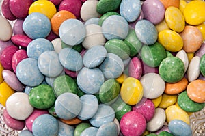 Colorful chocolate candies in a crystal bowl as background