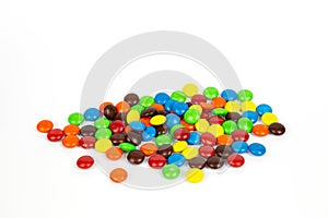 Colorful chocolate M&Ms in and out of focus on white background