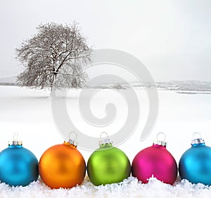 Colorful Christmas balls on snowfield