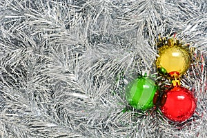 Colorful Christmas decoration ball on silver Christmas tinsel background