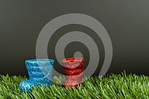 Colorful christmas decoration mini boots plastic on the lawn with a dark gray background