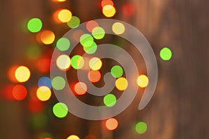 Colorful christmas garland lights on brown wooden background. Christmas Light with Copyspace for New Year Frame or Christmas Layou