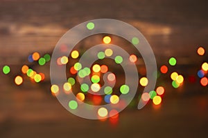 Colorful christmas garland lights on brown wooden background. Christmas Light with Copyspace for New Year Frame or Christmas Layou