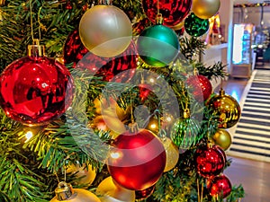 Colorful Christmas tree decorations and ornaments in a work place setting with shiny and gold style for winter holidays