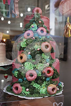Colorful Christmas tree-shaped cake is displayed in a shop window