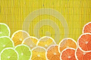 Colorful citrus slice on yellow bamboo texture