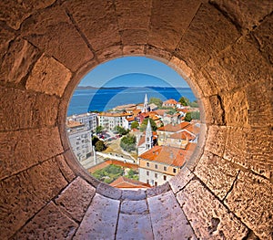 Colorful city of Zadar rooftops and towers view through stone window