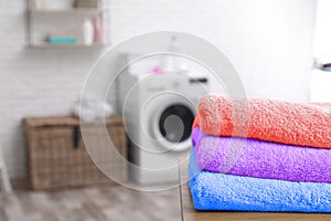 Colorful clean towels on table in laundry room