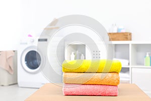 Colorful clean towels on table in laundry room