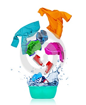 Colorful clothes flying out from blue wash bowl on white