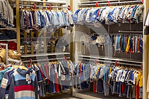 Colorful clothes hanging in children wardrobe