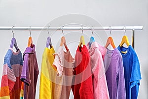 Colorful clothes hanging on wardrobe rack