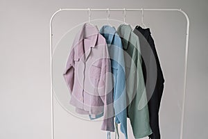 Colorful clothes Hanging on a White Metal Rack Against a Neutral Background