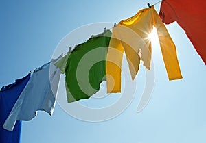 Colorful clothes on a laundry line and sun shining photo