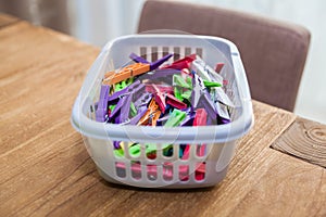 Colorful clothes pegs in plastic basket