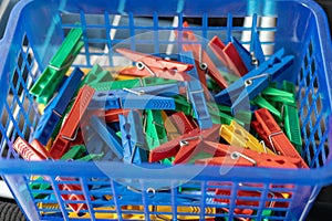 Colorful clothespins in a blue basket