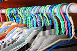 Colorful cloths hangers with office suit in closet orderly