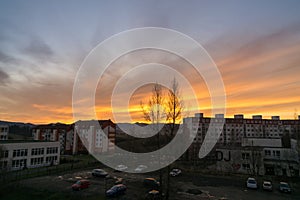 Colorful clouds over the city and buildings or park and meadow, during sunrise or sunset.