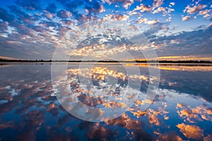 A colorful cloudy on sky is reflecting on water