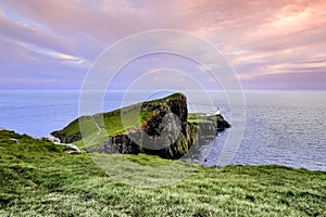 Colorful coastal sunset at Neist Point Lighthouse on Isle of Skye in Scotland, United Kingdom