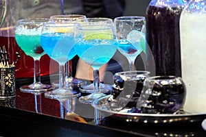 Colorful cocktails with ice on nightclub bar counter